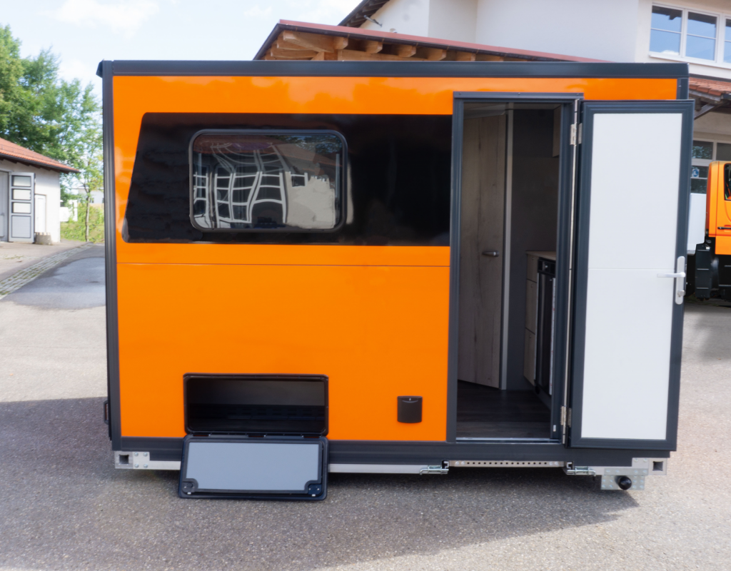Orangene Absetzkabine-6 mit Unimog im Hintergrund Versuch 3